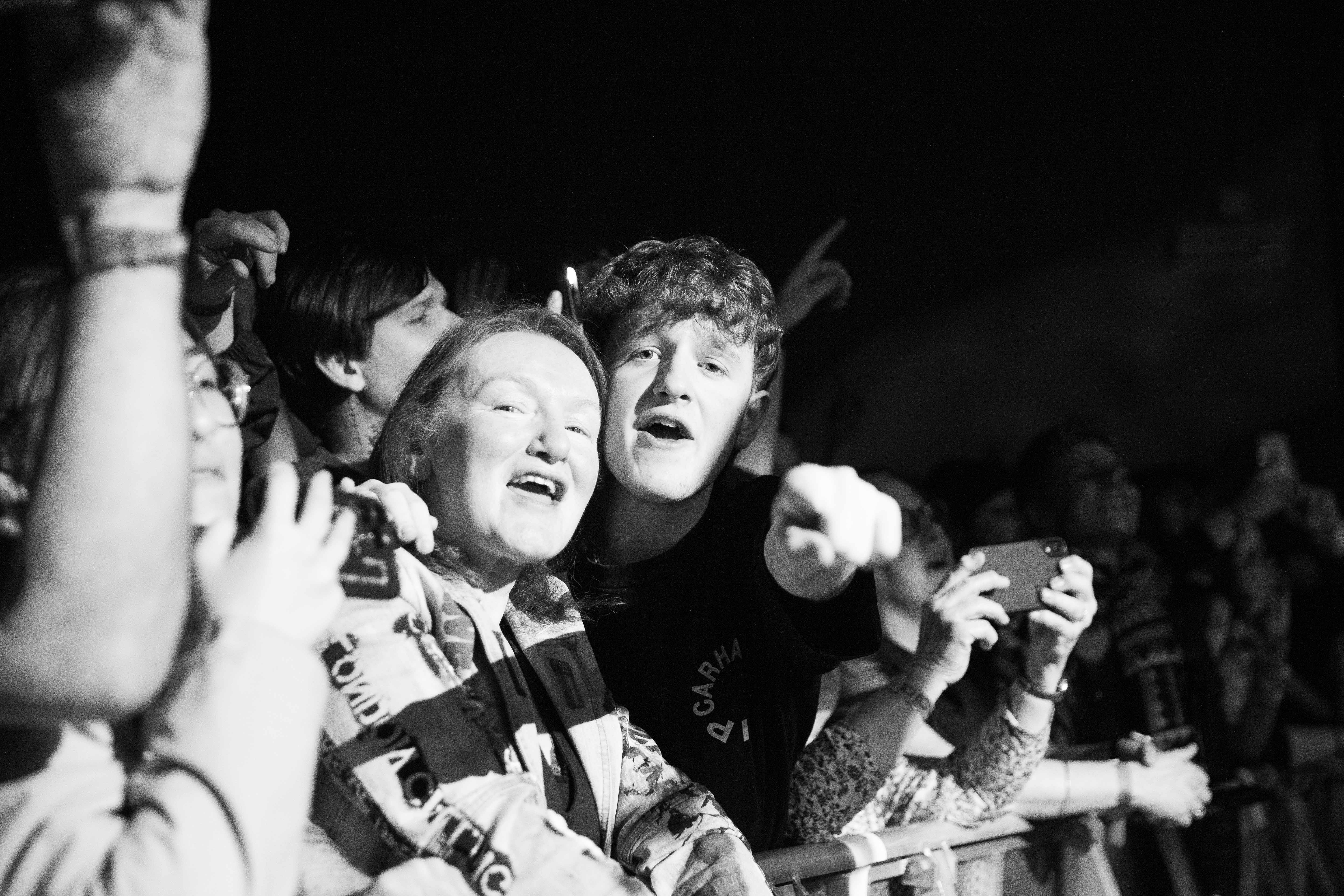 Members of the crowd pointing and singing towards the camera taking their photo while watching The Libertines play at Princess Pavilion Falmouth.